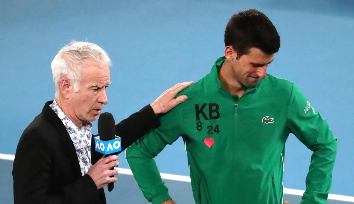 Reaksi Novak Djokovic saat diwawancarai tentang kematian Kobe Bryant usai mengalahkan Milos Raonic pada perempat final Australia Terbuka di Melbourne, Selasa (28/1/2020). Djokovic mengenakan jaket dengan inisial dan nomor punggung Kobe Bryant untuk menghormati temannya itu. (AP Photo/Dita Alangkara)