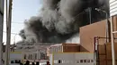 Kepulan asap hitam membumbung dari kebakaran gudang surat suara terbesar Irak di Baghdad, Minggu (10/6). Gudang tersebut menyimpan surat suara dari Al Russafa, salah satu wilayah pemilihan terbesar di bagian timur Baghdad. (AP/Karim Kadim)