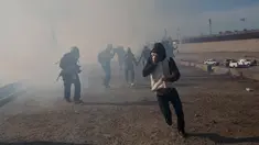 Imigran menghindari gas air mata petugas patroli perbatasan AS di dekat pagar pembatas antara Meksiko dan Amerika Serikat di Tijuana, Meksiko (25/11). Walikota Tijuana telah menyatakan krisis kemanusiaan di kota perbatasannya. (AP Photo/Rodrigo Abd)