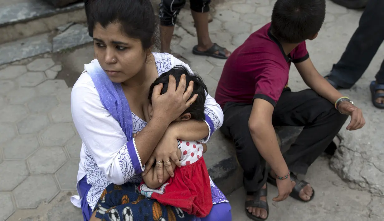 Seorang ibu tampak memeluk anaknya saat gempa susulan kembali melanda Nepal, Selasa (12/5/2015). Berdasarkan media setempat, kekuatan gempa mencapai 7,3 SR dan berlangsung lebih dari semenit. (REUTERS/Athit Perawongmetha)