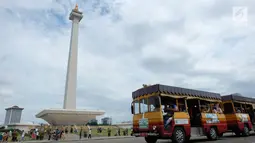 Sejumlah pengunjung menaki kereta wisata saat liburan di Monumen Nasional (monas), Jakarta, Selasa (25/12). Liburan Natal 2018, banyak warga datang bersama kerabat maupun keluarga memadati Monas. (Liputan6.com/Herman Zakharia)