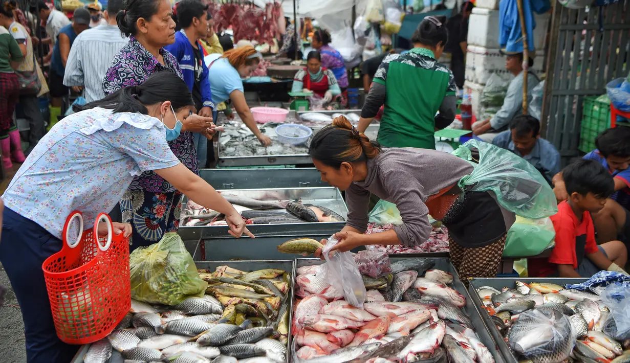 Seorang pelanggan memilih ikan dari penjual ikan di sebuah pasar di Phnom Penh (24/7/2020). Ibu kota Kamboja ini dipenuhi pasar baik besar maupun kecil. (AFP/Tang Chhin Sothy)