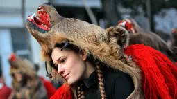 Seorang gadis mengenakan kostum beruang menari selama ritual tahunan di Piatra Neamt, Rumania Utara (28/12). Tradisi unik yang telah berusia ratusan tahun ini bertujuan untuk menangkal kejahatan. (AP Photo/Vadim Ghirda)