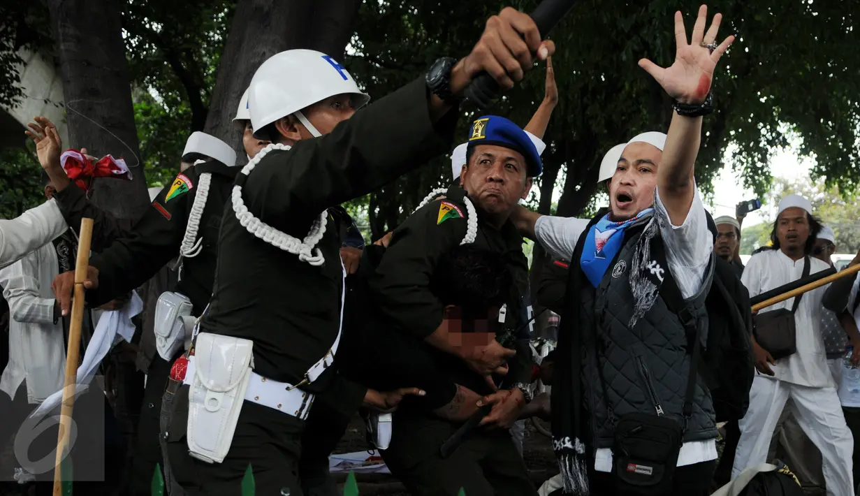 Seorang pria yang diduga provokator dalam aksi damai 2 Desember ditangkap oleh polisi Militer Angkatan Laut di kawasan Monas, Jakarta, Jumat (2/12). Pria itu tertangkap tangan membawa golok saat aksi damai tengah berlangsung. (Liputan6.com/Gempur M Surya)