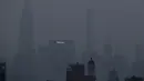 Bangunan Met Life dan Chrysler bersinar melalui kabut tebal yang menggantung di langit Manhattan, New York, Selasa (20/7/2021). Lebih dari 60 kebakaran hutan melanda sekitar 10 negara bagian di barat Amerika Serikat (AS), menyebabkan langit berkabut hingga New York.  (AP Photo/Julie Jacobson)