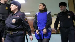  Gulchehra Bobokulova saat digiring petugas memasuki ruang sidang di Moskow, Rusia, Rabu (2/3). Wania berumur 38 tahun ini mengenakan burka setiap harinya. (REUTERS / Maxim Shemetov)