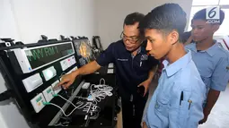 Siswa mendengarkan cara kerja integrated control system di SMK Ora et Labora, BSD Tangerang Selatan, Kamis (18/9). SMK yang baru diresmikan ini membantu program pemerintah mewujudkan pembangunan ketenagalistrikan. (Liputan6.com/Fery Pradolo)