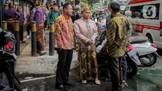 Keluarga pengantin yang menjalani resepsi di lantai 5 gedung K-Link Tower yang terbakar menunggu di trotoar Jl Gatot Subroto, Jakarta, Sabtu (15/7/2023). (Liputan6.com/Faizal Fanani)