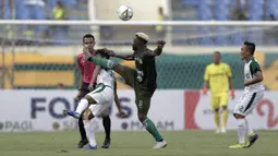 Gelandang Tira Persikabo, Essengeu Eloumou, berebut bola dengan pemain Persebaya pada laga Piala Presiden 2019 di Stadion Si Jalakl Harupat, Soreang, Bandung, Selasa (12/3). Persebaya bermain imbang 0-0  atas Tira Persikabo. (Bola.com/Yoppy Renato)