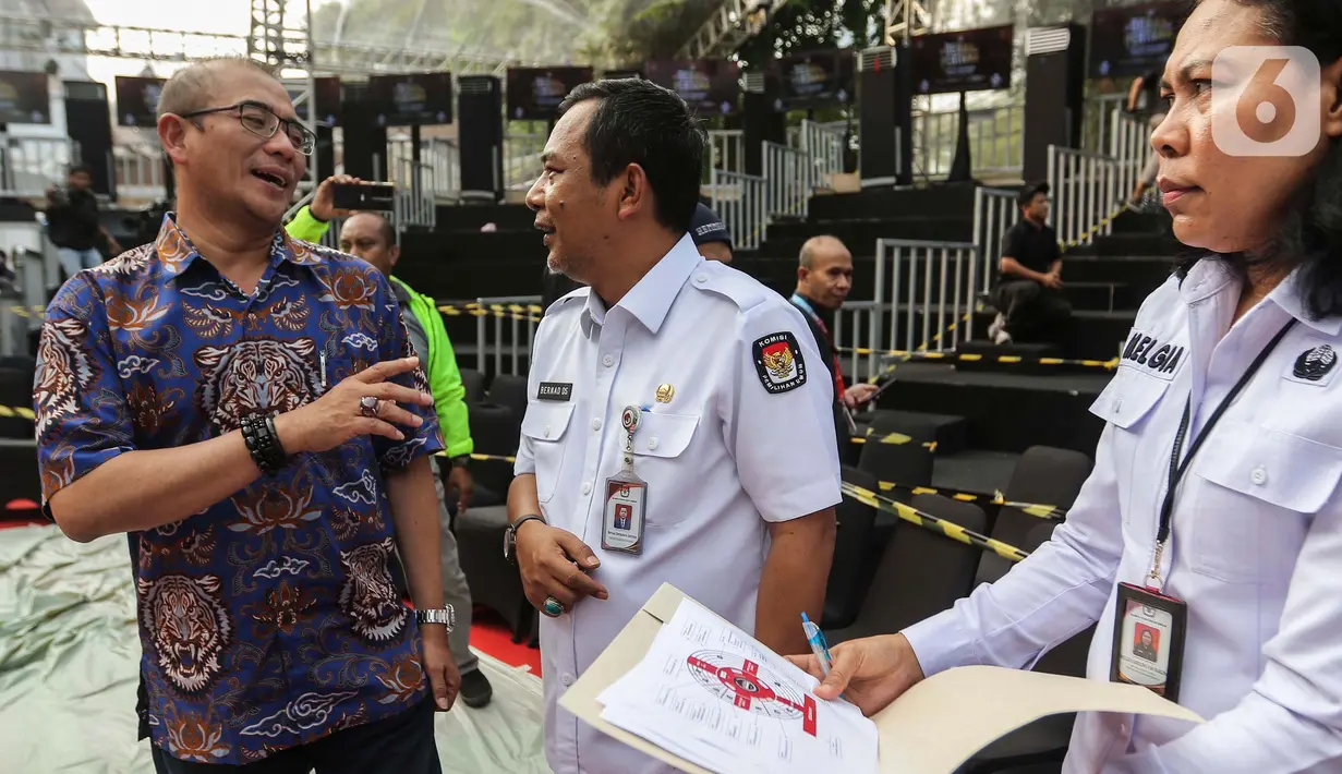 Ketua Komisi Pemilihan Umum (KPU) Hasyim Asy'ari (kiri) saat meninjau panggung debat Capres/Cawapres Pemilu 2024 di Halaman Gedung KPU, Jakarta, Senin (11/12/2023). (Liputan6.com/Angga Yuniar)