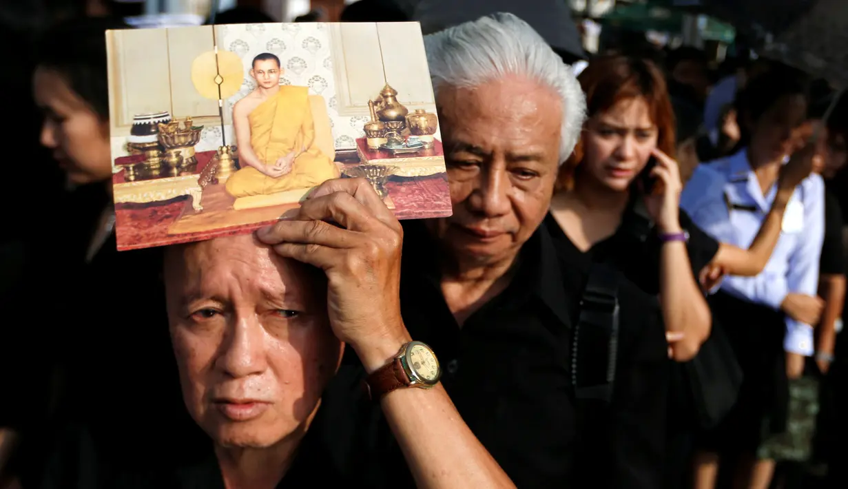 Pelayat berbaris memasuki Grand Palace untuk memberikan penghormatan terakhir kepada Raja Thailand Bhumibol Adulyadej di Bangkok, Jumat (14/10). Raja Bhumibol meninggal di usia 88 tahun. (Reuters/Jorge Silva)