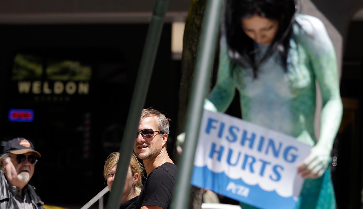 Aksi menolak penangkapan ikan di Seattle, AS, Senin (5/6). Victoria Lemeow dikait selama satu jam sebagai bentuk empati kepada ikan saat mereka ditangkap untuk dikonsumsi manusia. (AP Photo / Elaine Thompson)