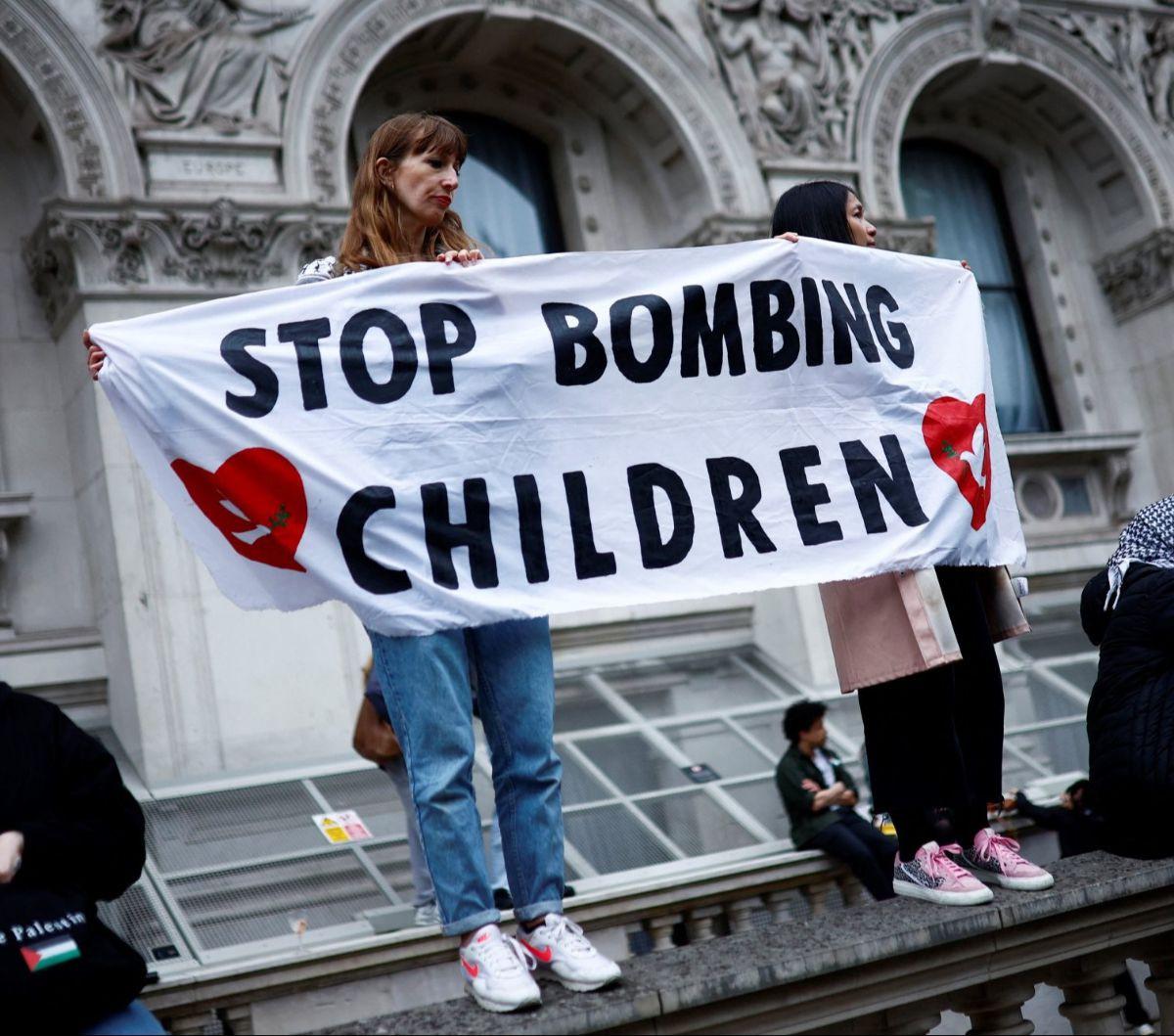 Pengunjuk rasa membentangkan spanduk bertuliskan 'Stop bombing children' saat menggelar aksi solidaritas untuk Palestina di London, Inggris, pada 28 Mei 2024. Dalam aksinya, ribuan pengunjuk rasa di London ini mengecam genosida yang dilakukan Israel di Ja