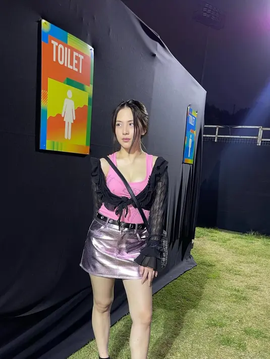 OOTD nonton konser dari Zara. Ia tampil cantik mengenakan tank top pink ditumpuk dengan cropped outer hitam yang transparan, dipadu silver mini skirt dan sling bag hitam. [Foto: Instagram/zaraadhsty]
