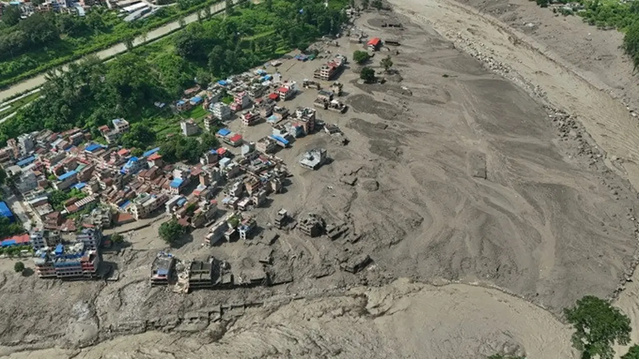 Rumah-rumah yang rusak terlihat nyaris ambruk di tepi Sungai Trishuli yang meluap dan dipenuhi puing setelah banjir bandang melanda Distrik Nuwakot, Nepal, Rabu (26/8/2026).