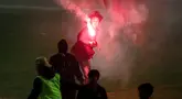 Seorang suporter menyalakan flare di dalam lapangan saat berlangsungnya laga leg kedua final Pegadaian Liga 2 2023/2024 antara Semen Padang mengadapi PSBS Biak di Stadion GOR Haji Agus Salim, Padang, Sabtu (9/3/2024). (Bola.com/Bagaskara Lazuardi)