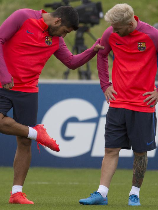 Luis Suarez menunjukan sepatu barunya kepada Messi saat sesi latihan tim Barcelona jelang laga melawan Celtic pada ajang International Champions Cup 2016 di St George's Park, Inggris (25/7/2016). (AFP/Oli Scarff)