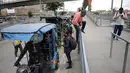 Seorang pria melompati rel untuk menggunakan bicitaxi sebagai alternatif transportasi setelah penghancuran beberapa stasiun layanan umum selama protes terhadap pemerintah Presiden Kolombia Ivan Duque, di Bogota (24/5/2021). (AFP/ Raul Arboleda)