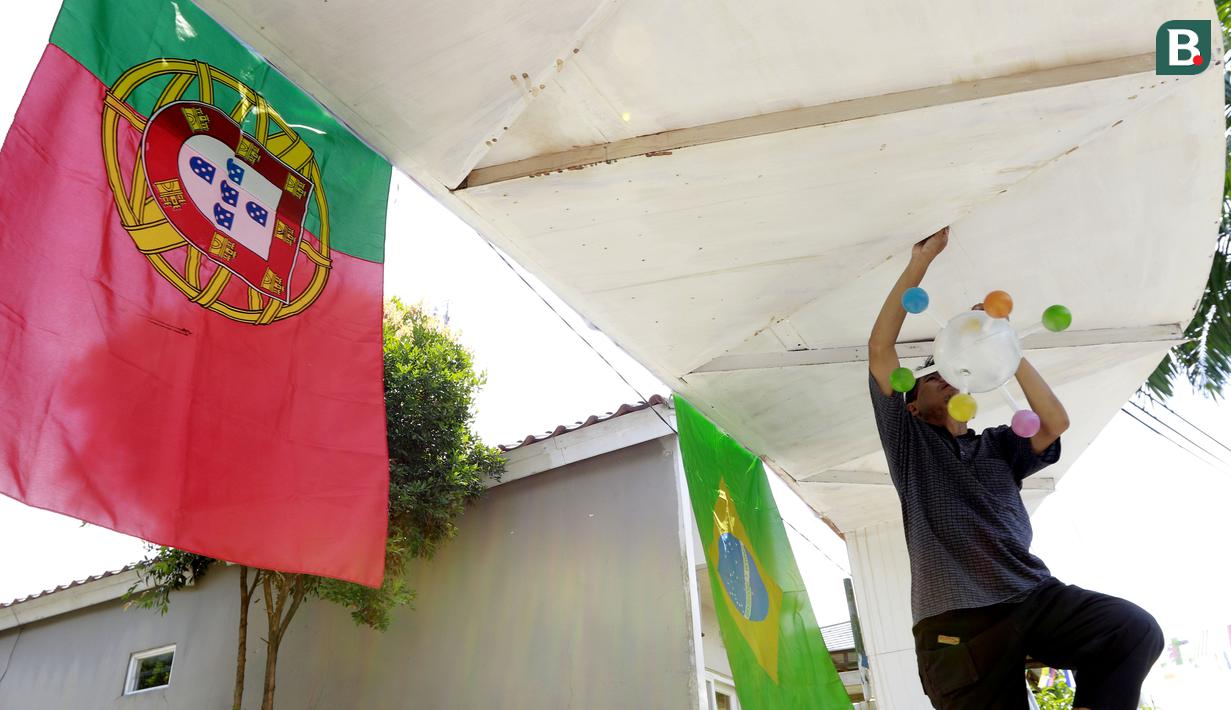 Warga memasang pernak pernik bertema Piala Dunia 2022 di Perum Depok Maharaja Blok M1 Cluster Cemara, Rangkapan Jaya, Depok, Jawa Barat, Minggu (30/10/2022). (Bola.com/M Iqbal Ichsan)