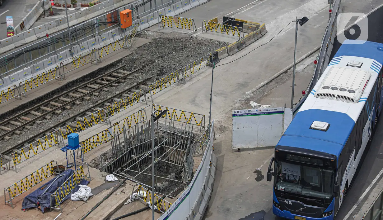 Transjakarta melintas dekat lokasi ditemukannya rel trem di lokasi pembangunan MRT Jakarta fase 2, Glodok, Jakarta, Selasa (28/12/2021). Rel trem itu ditemukan di bawah jalur TransJakarta di Jalan Pintu Besar Selatan pada Desember 2021. (Liputan6.com/Faizal Fanani)