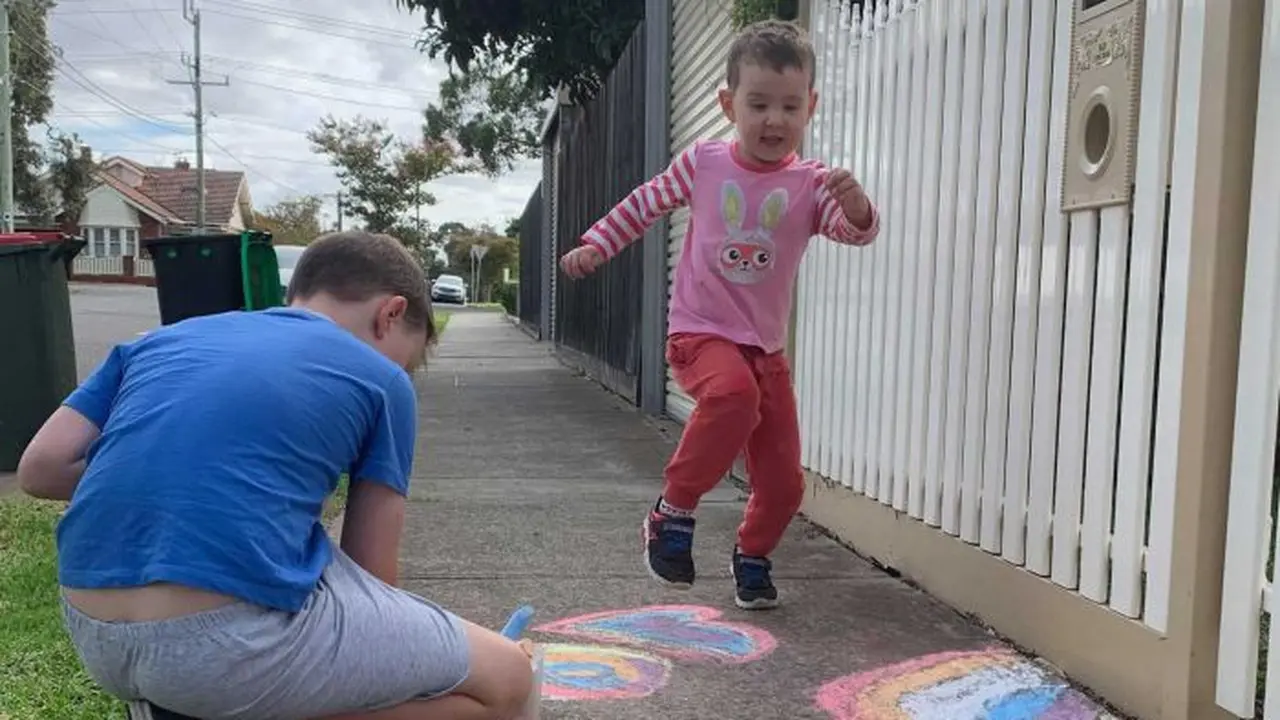 Max, menggambar pelangi yang dilihat oleh adiknya, Lenny, di kawasan Essendon, Melbourne. (Supplied: Dian Turner)