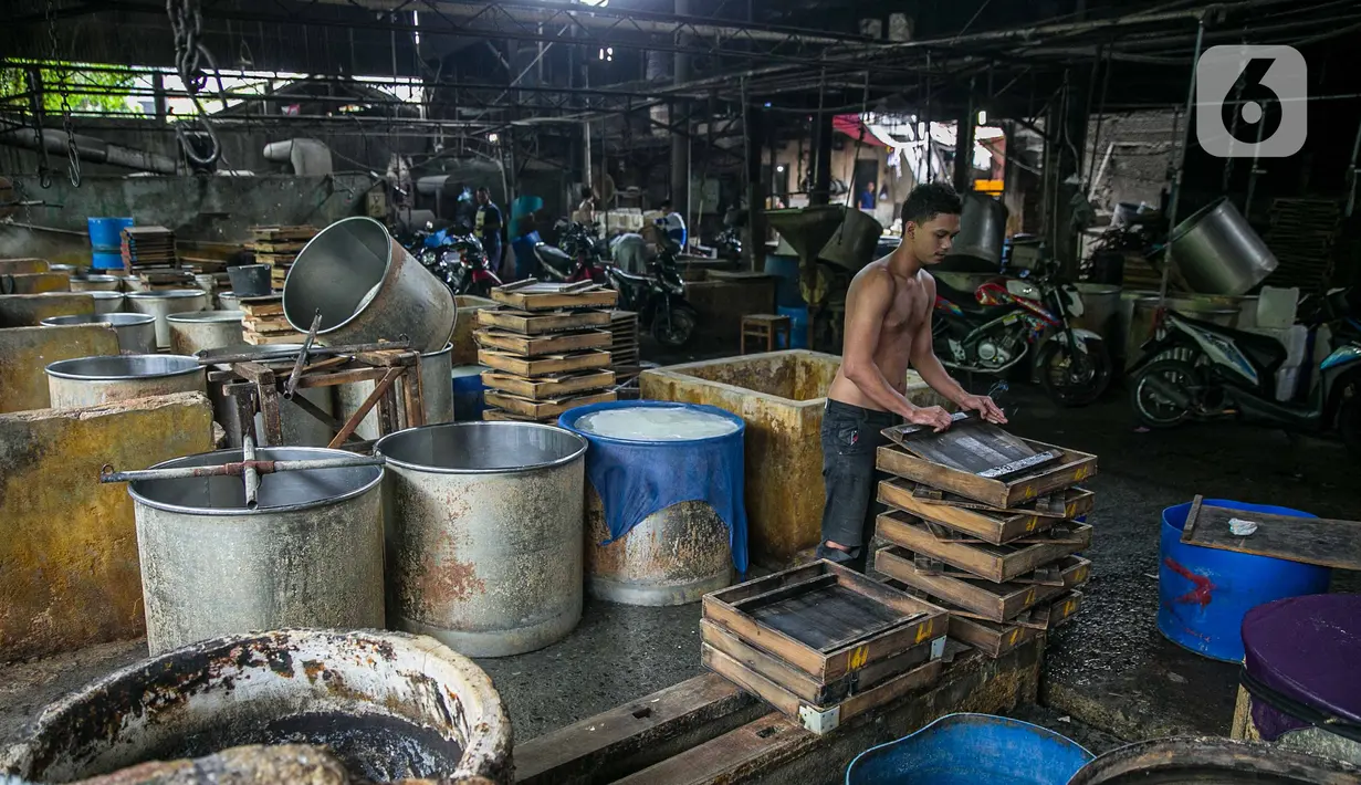 Pekerja merapikan tatakan di pabrik tahu tempe yang berhenti operasi di kawasan Duren Tiga, Jakarta, Sabtu (2/12/2021). Penghentian sementara proses produksi tempe dan tahu mulai Jumat, 1 Januari hingga Minggu, 3 Januari 2021. (Liputan6.com/Faizal Fanani)