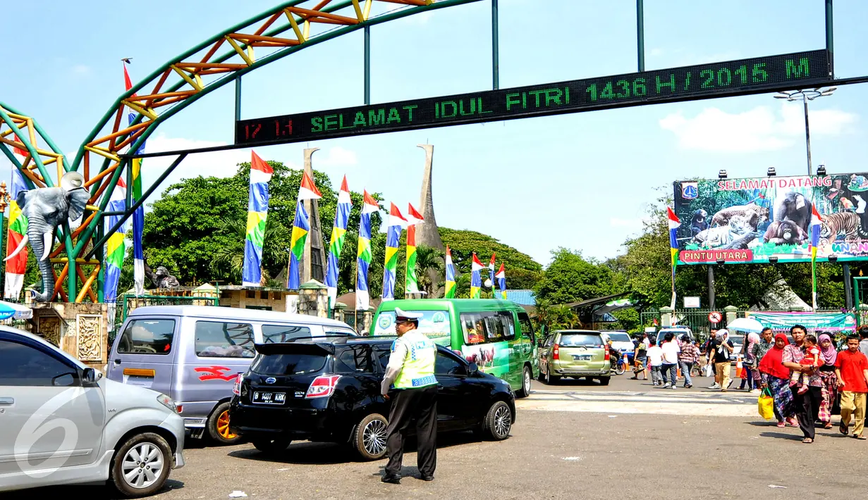 Petugas kepolisian membantu mengatur kendaraan yang hendak ingin memasuki lokasi wisata Kebun Binatang Ragunan, Jakarta Selatan, Sabtu (18/7/2015). Kendati ramainya pengunjung, keadaan lalu lintas di Ragunan cenderung normal. (Liputan6.com/Yoppy Renato)