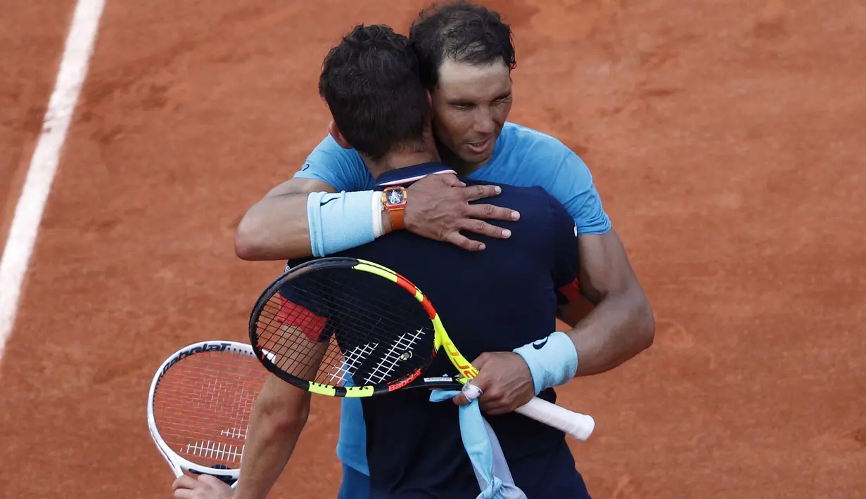 Rafael Ndal memberikan saaat memeluk Dominic Thiem usai laga final Prancis Terbuka 2018 di Roland Garros stadium, Paris, (10/6/2018). Nadal menang tiga set 6-4, 6-3, 6-2. (AP/Christophe Ena)
