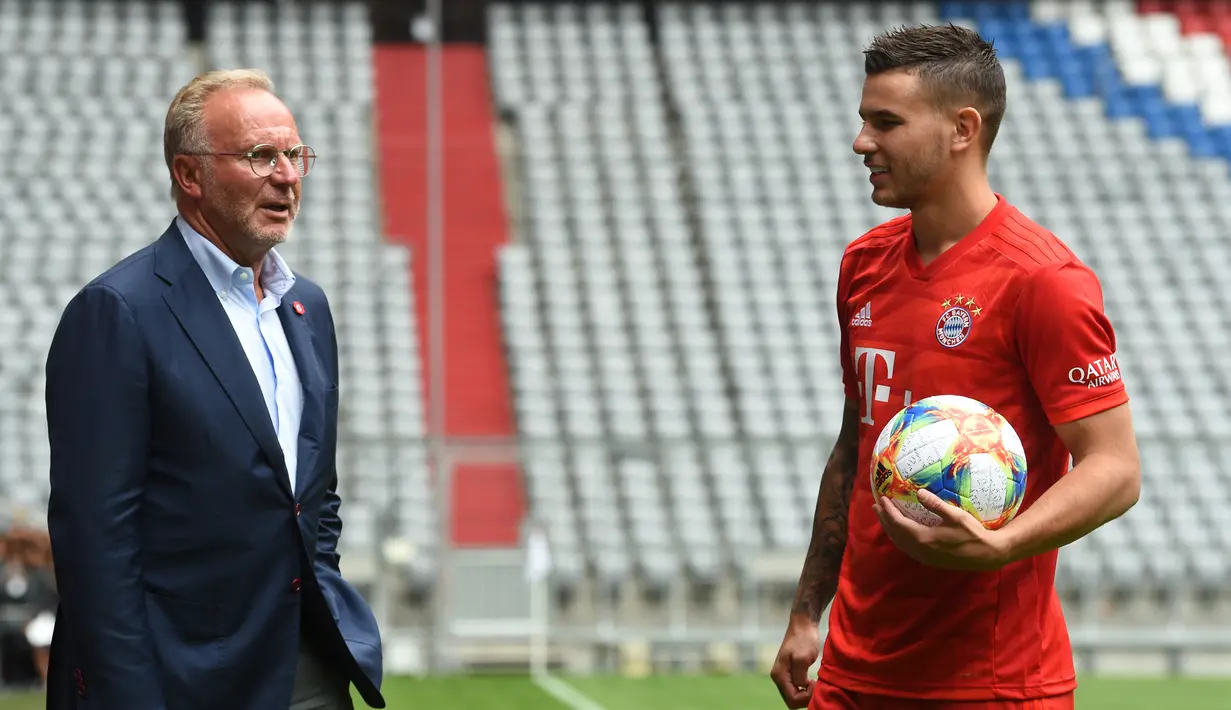 Bek baru Bayern Munchen, Lucas Hernandez berbincang dengan CEO Bayern Munchen, Karl-Heinz Rummenigge saat dirinya diperkenalkan secara resmi di Allianz Arena, Munich, Senin (8/7/2019). Pemain 23 tahun ini diikat kontrak selama lima tahun atau hingga 2024 oleh Bayern Munchen. (Christof STACHE/AFP)