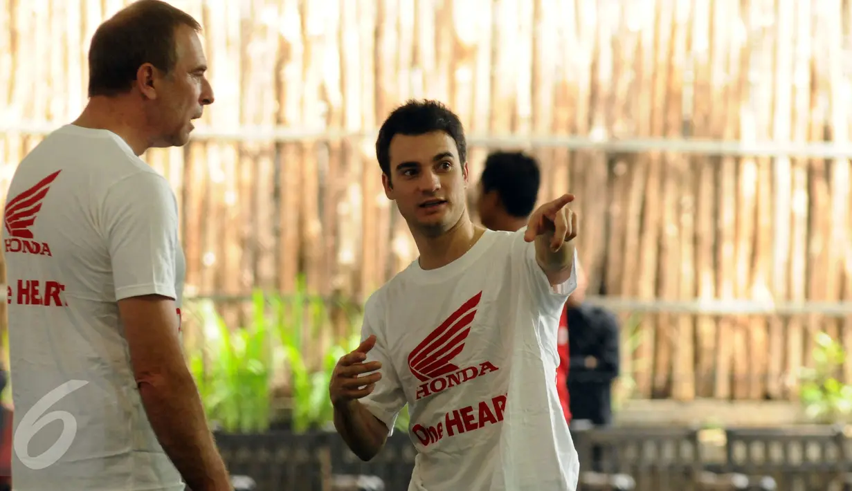 Pebalap MotoGP Repsol Honda, Dani Pedrosa (kanan) berbincang dengan kru tim Honda jelang bermain futsal di Jakarta, Sabtu (13/2/2016). Tim Repsol Honda MotoGP 2016 akan diperkenalkan, Minggu (14/2) di Sirkuit Sentul. (Liputan6.com/Helmi Fithriansyah)