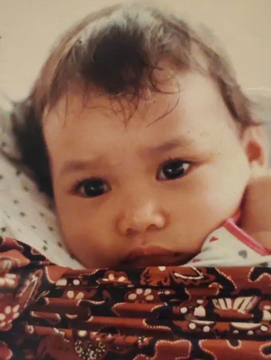 Mata belo dan bulu mata lentik menjadi daya tarik seorang Adinia Wirasti sejak kecil. Pipi gembulnya membuat siapapun yang melihatnya merasa gemas. Diketahui ini adalah potret Adinia Wirasti saat usianya masih beberapa bulan. Tak terasa bayi yang anteng dalam gendongan ini sudah menjadi artis bersinar dengan segudang karya, prestasi dan penghargaan yang diraihnya. (Liputan6.com/IG/@adiniawrst)