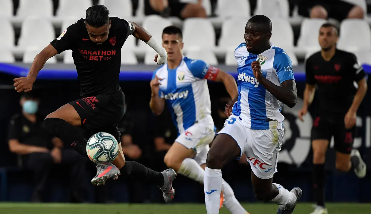Penyerang Sevilla, Youssef En-Nesyri, berebut bola dengan gelandang Leganes, Ibrahim Amadou, pada laga lanjutan La Liga pekan ke-33 di Estadio Municipal de Butarque, Rabu (1/7/2020) dini hari WIB. Sevilla menang 3-0 atas Leganes. (AFP/Pierre-Philippe Marcou)