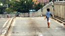 Seorang anak melintas di Jalan Jatinegara Barat Jakarta, Kamis (20/8/2015). Jalan Jatinegara Barat ditutup saat penggusuran warga yang tinggal di bantaran Kali Ciliwung di Kampung Pulo, Jakarta Timur. (Liputan6.com/HelmiFithriansyah)