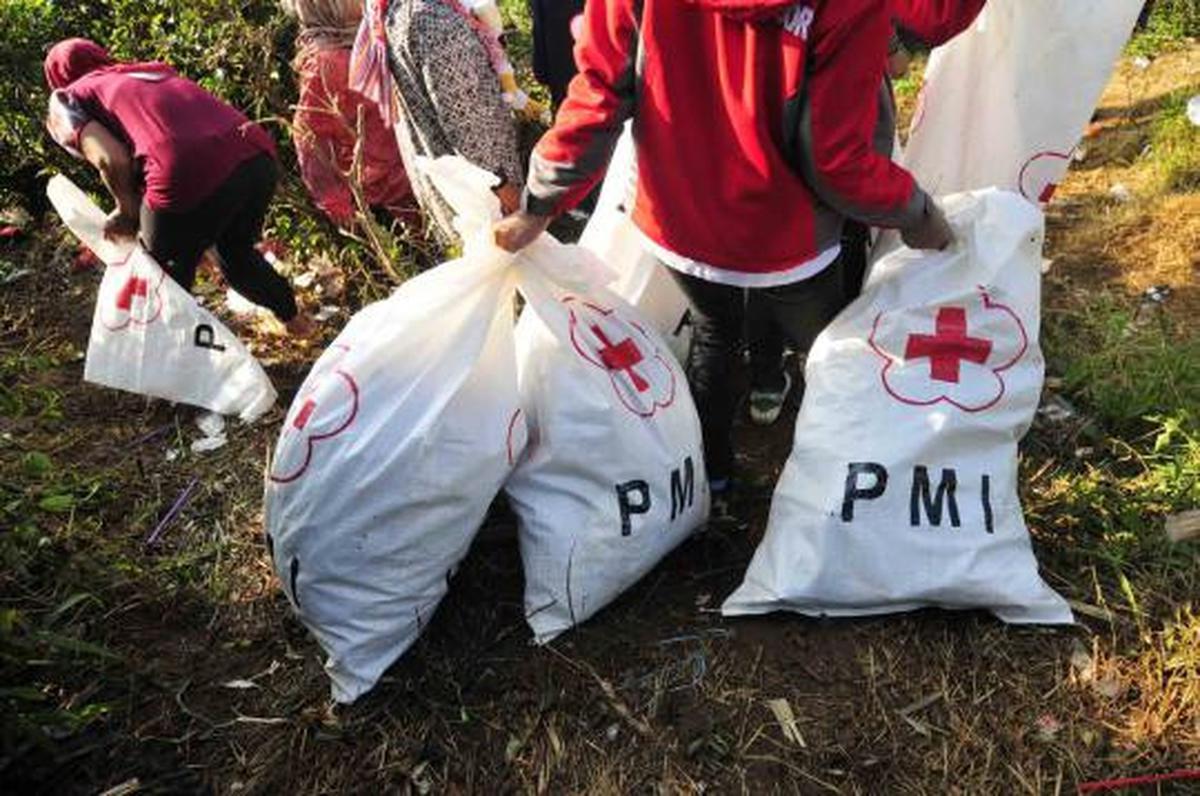 Relawan PMI dan TNI dibantu warga sekitar melakukan bersih   bersih di 