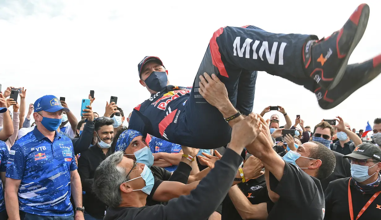 Pereli asal Prancis, Stephane Peterhanse, bersama timnya merayakan juara Reli Dakar 2021 di Arab Saudi, Jumat (15/1/2021). Stephane Peterhanse berhasil menambah rekor juaranya menjadi 14 kali juara Reli Dakar. (AFP/Franck Fife)