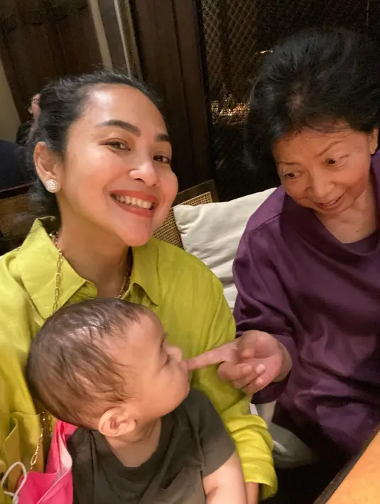 Feni Rose asyik berpose seorang diri, sementara sang cucu malah menatap gemas seorang nenek yang menggodanya. (Foto: Instagram/@fenirose)