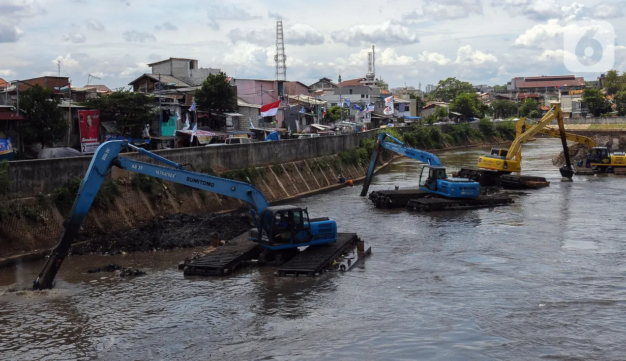 Ekskavator mengeruk endapan material lumpur pada aliran Kali Ciliwung di Jakarta, Selasa (16/1/2023). Proyek ini dilakukan untuk mengurangi pendangkalan kali dan bagian dari program pencegahan penanggulangan banjir yang sudah masuk musim penghujan. (merdeka.com/Imam Buhori)