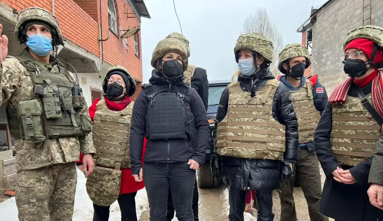 Menteri Luar Negeri Jerman Annalena Baerbock (tengah) mengunjungi Shyrokyne di Wilayah Donetsk, Ukraina (8/2/2022). Menurut kantor berita Jerman DPA, tidak ada kekerasan yang terjadi selama kunjungan Annalena Baerbock. (Handout/Ukrainian Foreign Ministry press-service/AFP)