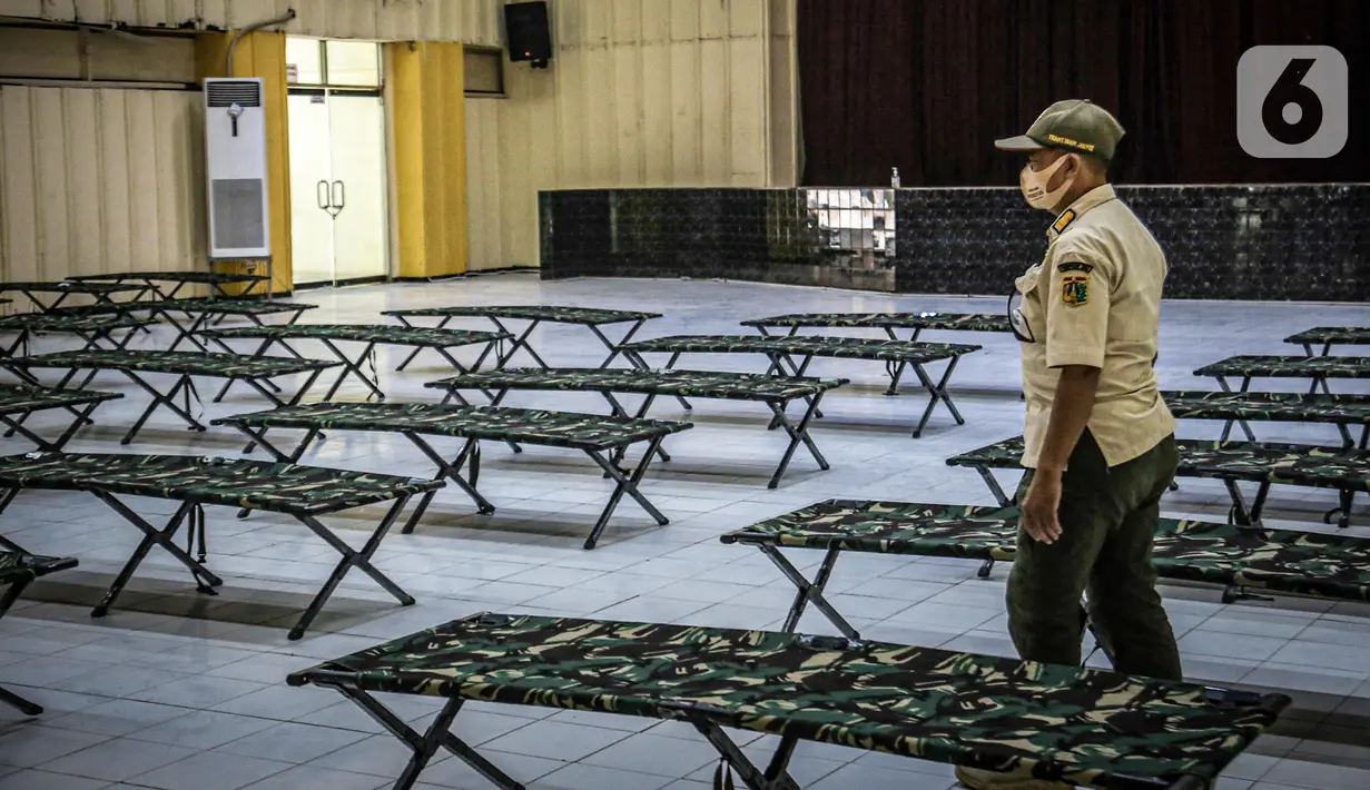 Petugas Satpol PP mengecek tempat karantina untuk pendatang tanpa SIKM di Gedung Auditorium Gelanggang Remaja Gambir, Jakarta, Rabu (27/5/2020). (Liputan6.com/Faizal Fanani)