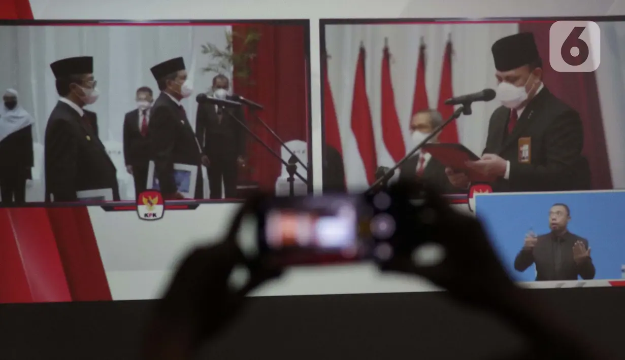 Pewarta merekam prosesi pengambilan sumpah janji jabatan pegawai KPK menjadi Aparatur Sipil Negara di Gedung Merah Putih KPK, Jakarta, Selasa (1/6/2021). Pelantikan 1.271 pegawai KPK menjadi Aparatur Sipil Negara dilakukan secara daring dan luring terbatas. (Liputan6.com/Helmi Fithriansyah)