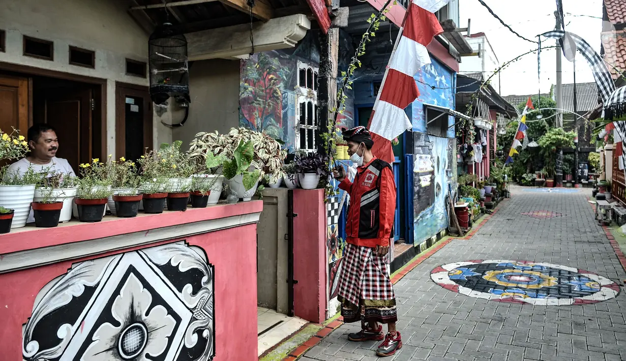 Puryanto (50) yang bertugas sebagai pecalang menyapa warga non Hindu saat berkeliling menjaga berlangsungnya perayaan Hari Raya Nyepi di Kampung Bali, Harapan Jaya, Bekasi, Jawa Barat, Minggu (14/3/2021). Jarang warga beraktivitas di luar rumah selama Nyepi berlangsung. (merdeka.com/Iqbal S Nugroho)