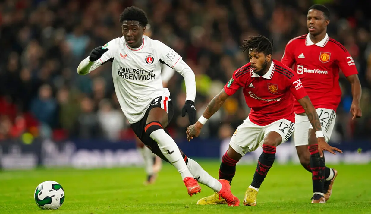 Pemain Manchester United Fred (kedua kanan) dan Tyrell Malacia (kanan) mencoba merebut bola dari pemain Charlton Athletic Jesurun Rak-Sakyi pada pertandingan sepak bola perempat final Piala Liga Inggris atau Carabao Cup di Old Trafford, Manchester, Inggris, 10 Januari 2023. Manchester United menang 3-0. (AP Photo/Dave Thompson)