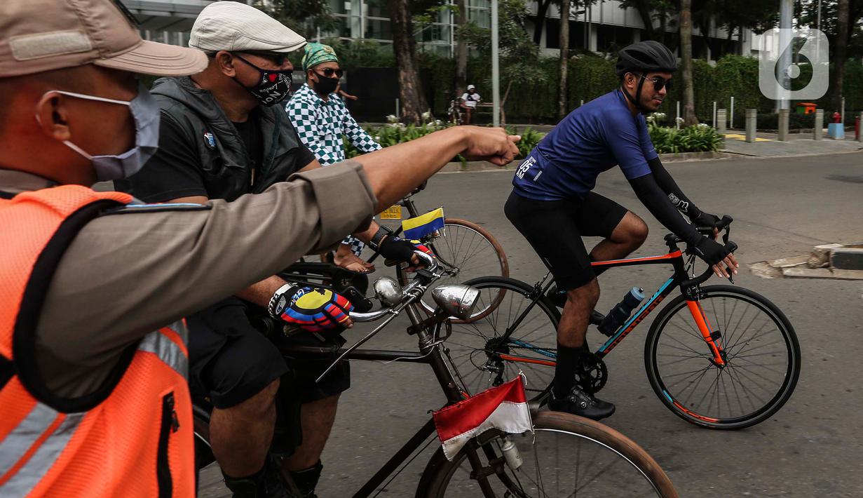 Satpol PP menegur pesepeda yang tidak mengenakan masker dengan benar di kawasan Bundaran HI, Jakarta, Minggu (17/1/2021). Pemerintah terus melakukan berbagai upaya guna mencegah penyebaran COVID-19 dan menurunkan angka masyarakat yang terpapar virus corona. (Liputan6.com/Johan Tallo)