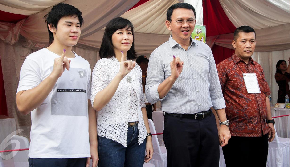 Calon gubernur DKI, Basuki Tjahaja Purnama (Ahok) bersama istri, Veronica Tan dan anaknya Nicholas Sean menunjukkan tinta pada jarinya usai mencoblos pada Pilkada DKI putaran kedua di TPS 54, Pluit, Jakarta Utara, Rabu (19/4). (Liputan6.com/Faizal Fanani)