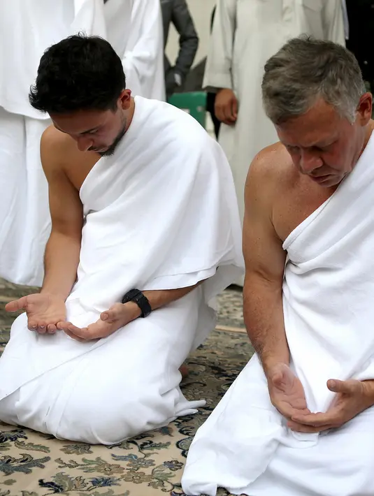 Raja Yordania, Abdullah II bin Al Hussein dan putranya Putra Mahkota Hussein bin Abdullah berdoa saat melakukan umrah pada bulan Ramdan di kota suci Mekkah (10/6). (AFP Photo/Jordanian Royal Palace/Yousef Allan)