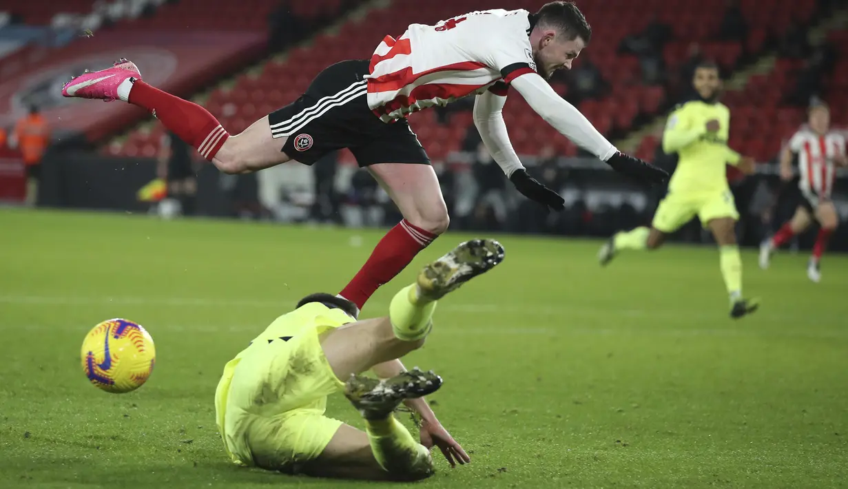 Gelandang Sheffield United, Oliver Burke dan bek Newcastle, Federico Fernandez berebut bola pada laga pekan ke-18 Liga Inggris di Bramall Lane, Rabu (13/1/2021) dini hari WIB. Sheffield memetik kemenangan perdana di Liga Inggris musim ini usai menang 1-0 atas Newcastle (Molly Darlington/Pool via AP)