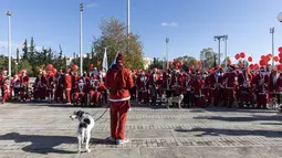 Orang-orang yang mengenakan kostum Sinterklas menunggu di garis start Athena Santa Run, di Athena, Yunani, Minggu (12/12/2021). Ratusan orang berpartisipasi mengikuti lomba lari untuk acara amal di area sekitar kompleks Stadion Olimpiade Athena. (AP Photo/Yorgos Karahalis)