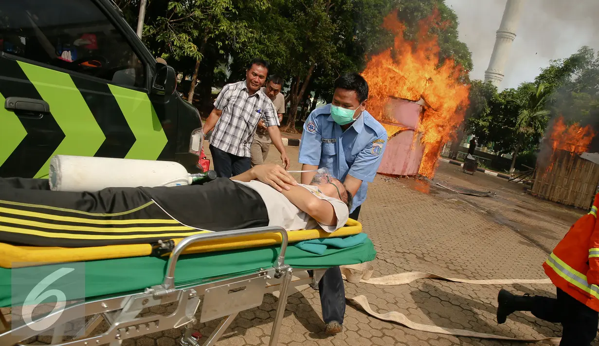 Petugas menolong warga korban kebakaran saat simulasi penanganan bencana di Jakarta, Kamis (10/12). Guna mengantisipasi banjir khususnya pada musim penghujan dan air pasang, berbagai persiapan dilakukan Pemkot Jakarta Utara. (Liputan6.com/Faizal Fanani)