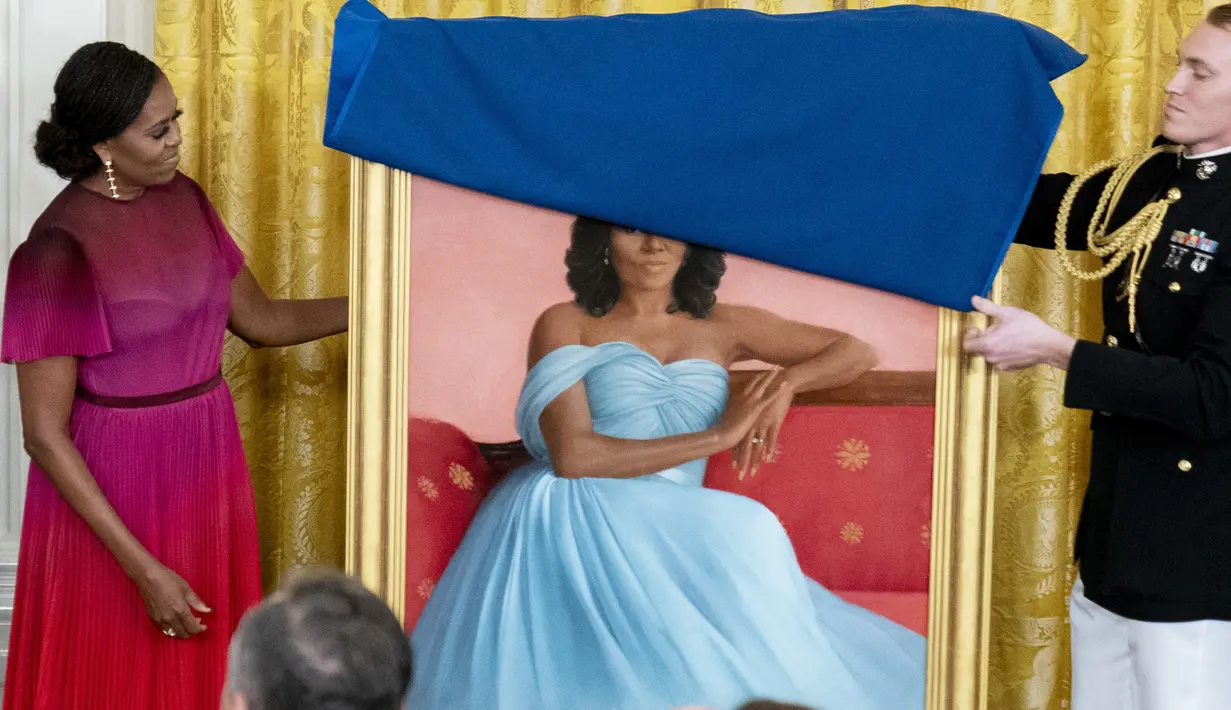 Mantan ibu negara Michelle Obama bersiap mengungkap potret resmi dari lukisannya yang akan menjadi koleksi Gedung Putih di Ruang Timur Gedung Putih, Washington, Rabu (7/9/2022).  Michelle Obama dilukis dengan posisi duduk, dengan mengenakan gaun berwarna biru muda. (AP Photo/Andrew Harnik)