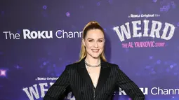 Evan Rachel Wood berpose sambil tersenyum saat menghadiri pemutaran perdana film "Weird: The Al Yankovic Story" di Alamo Drafthouse Cinema Downtown Brooklyn di New York pada Selasa, 1 November 2022. Wanita 35 tahun itu tampak gothic chic dalam balutan long dress bergaris yang dipadukan dengan high heels hitam. (Theo Wargo/Getty Images/AFP)